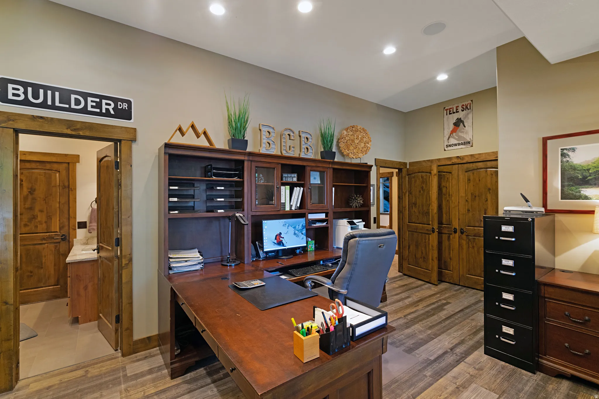 Dedicated office space featuring wood-finish flooring and recessed lighting