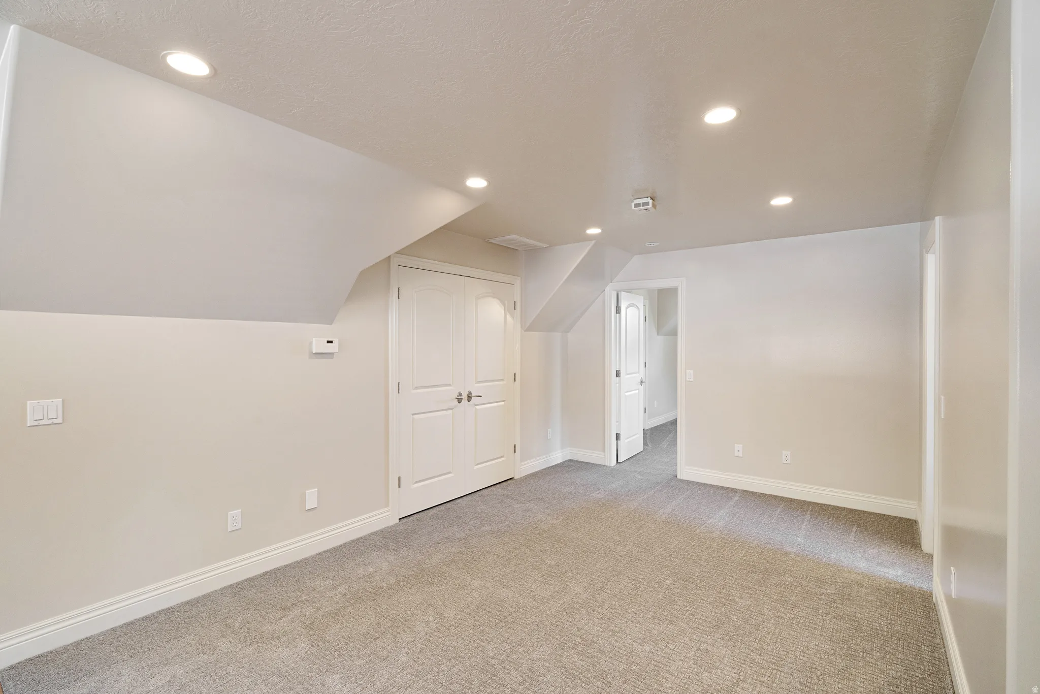 Carpeted room featuring recessed lighting, a double-door closet, and neutral wall tones