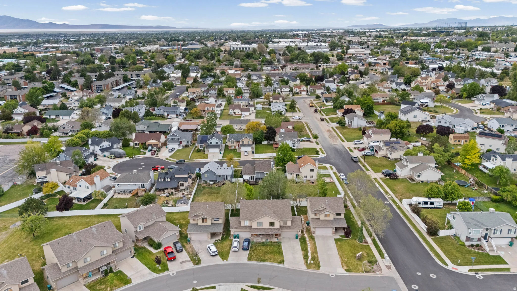 Suburban neighborhood featuring a mix of single-family residences with varied architectural styles, mature trees, and paved streets