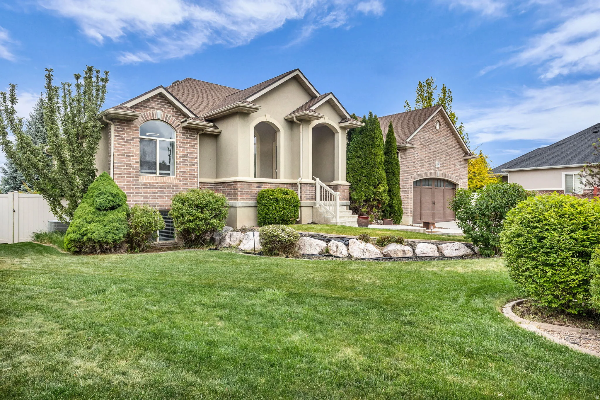 Two-story residence featuring a brick and stucco exterior