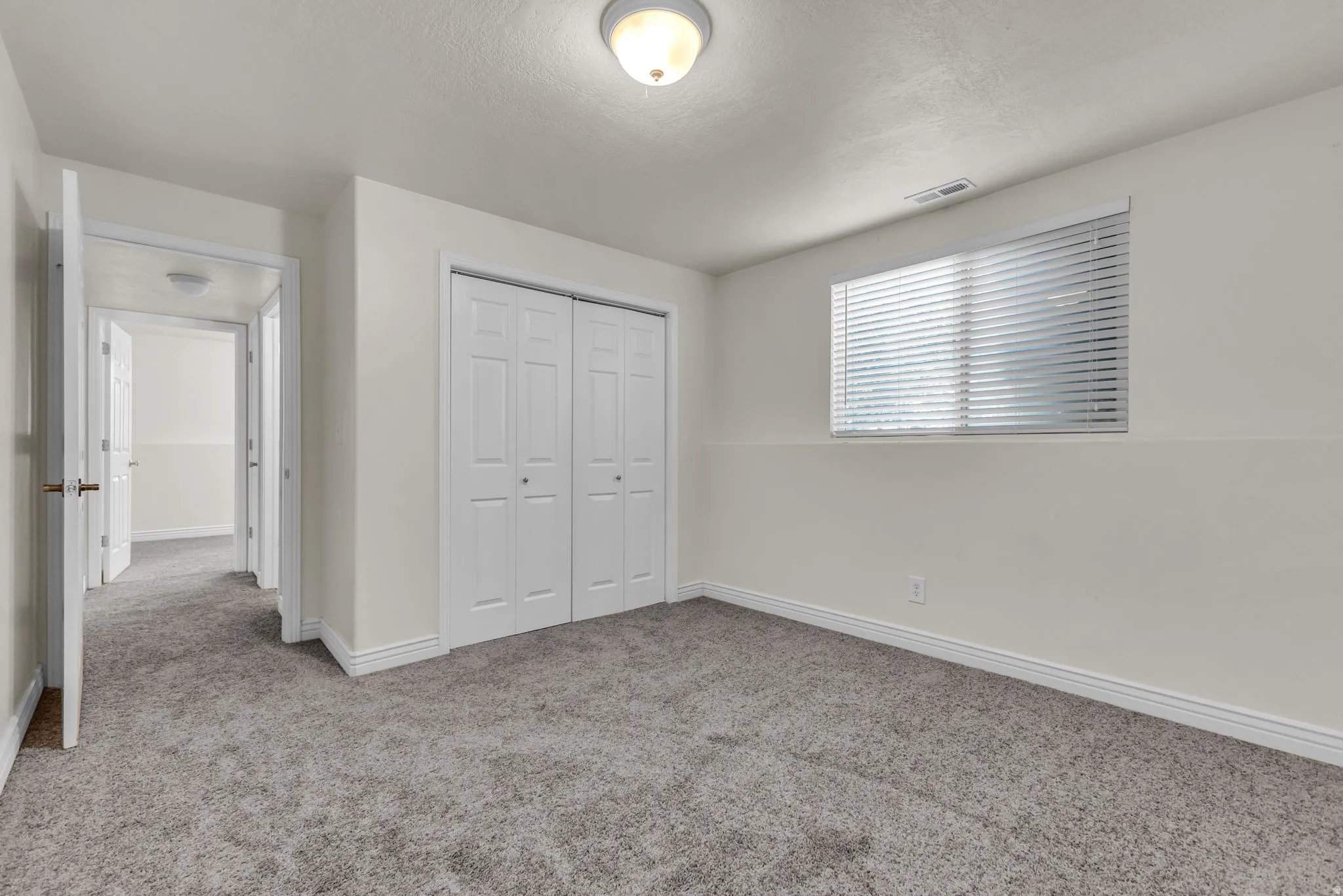 Neutral wall paint throughout this carpeted room