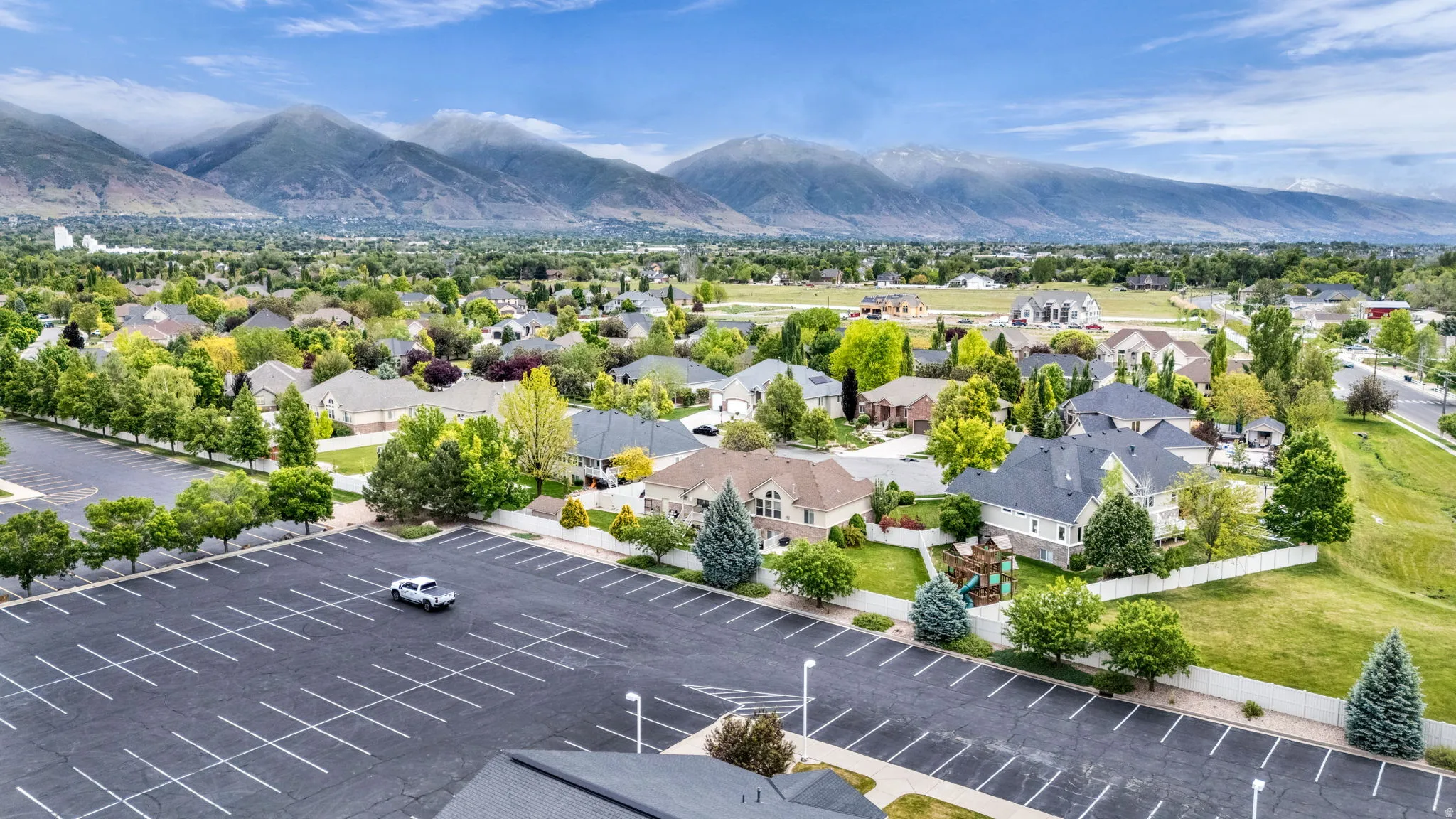 Expansive residential community featuring diverse architectural styles and mature landscaping, framed by distant mountains