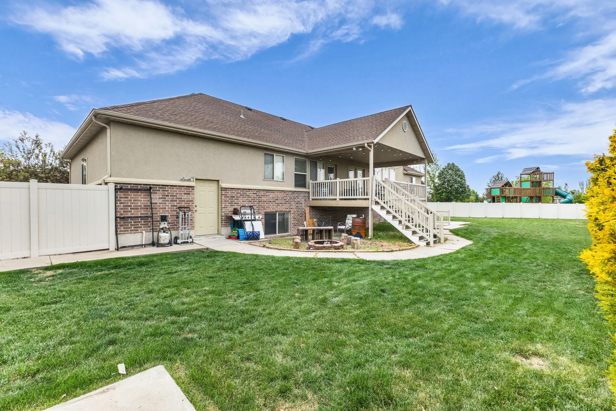 Expansive green lawn with a white privacy fence