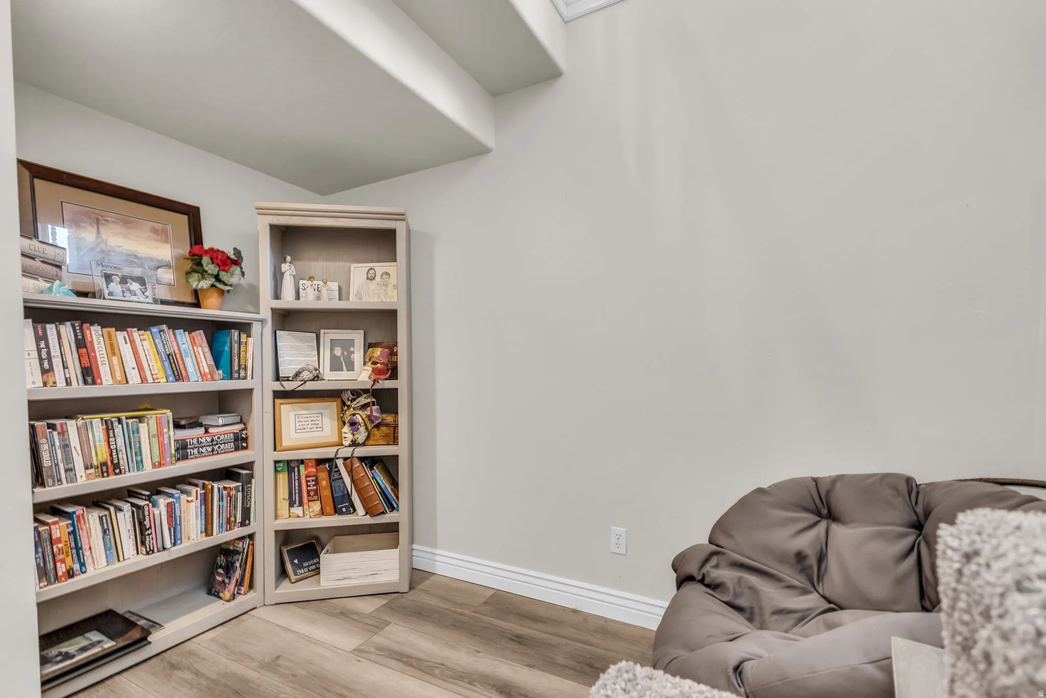 Alcove with two built-in bookcases, light gray walls, white baseboards, and wood-finish flooring
