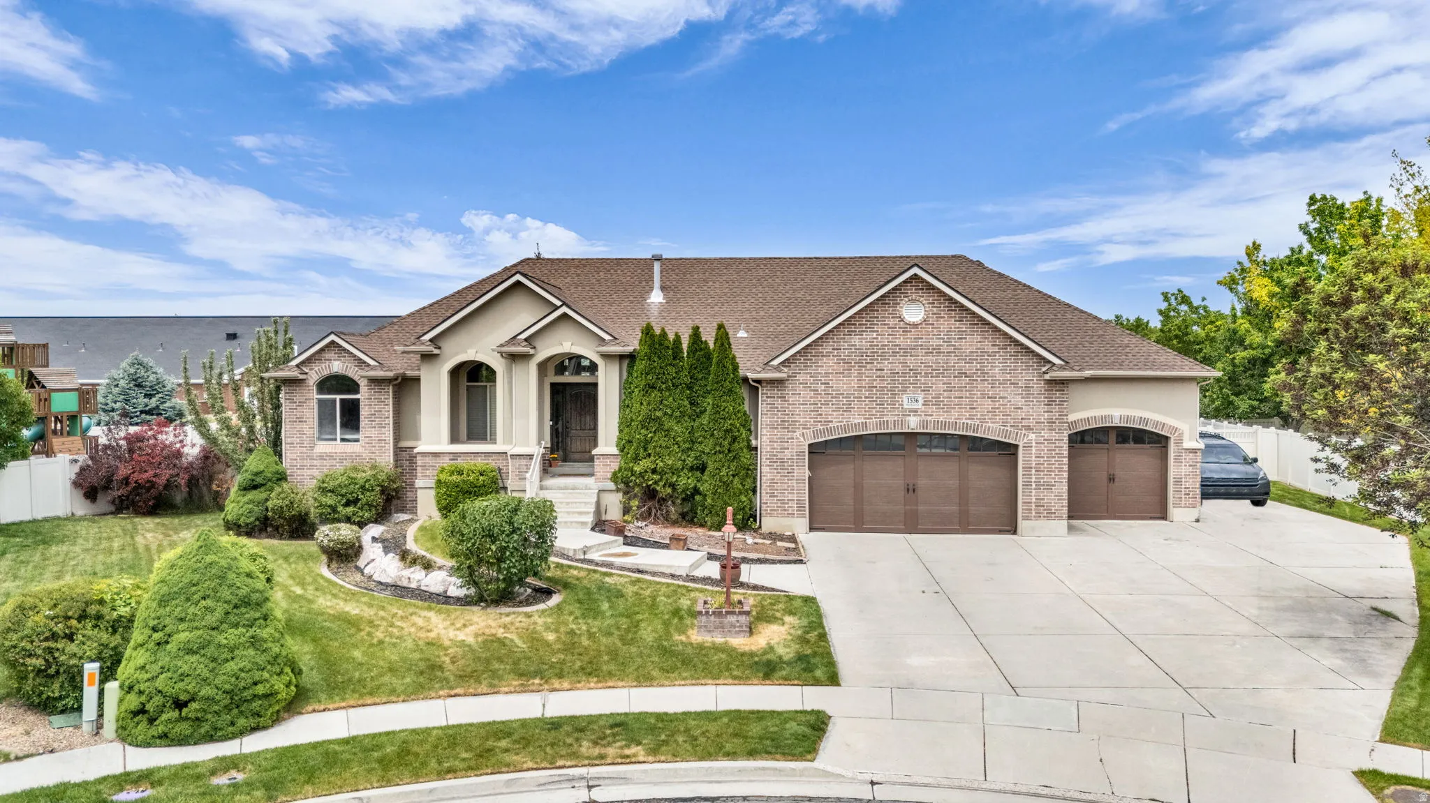 Brick and stucco exterior with a multi-car driveway