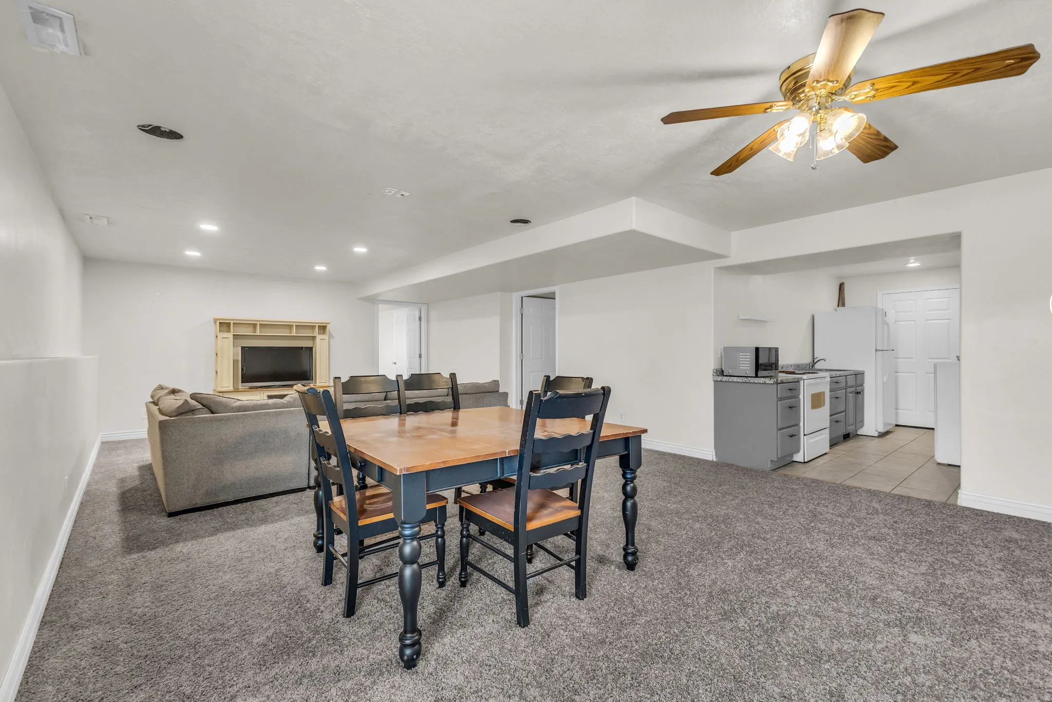 Open-concept living space featuring gray carpeting, recessed lighting, and a built-in media niche