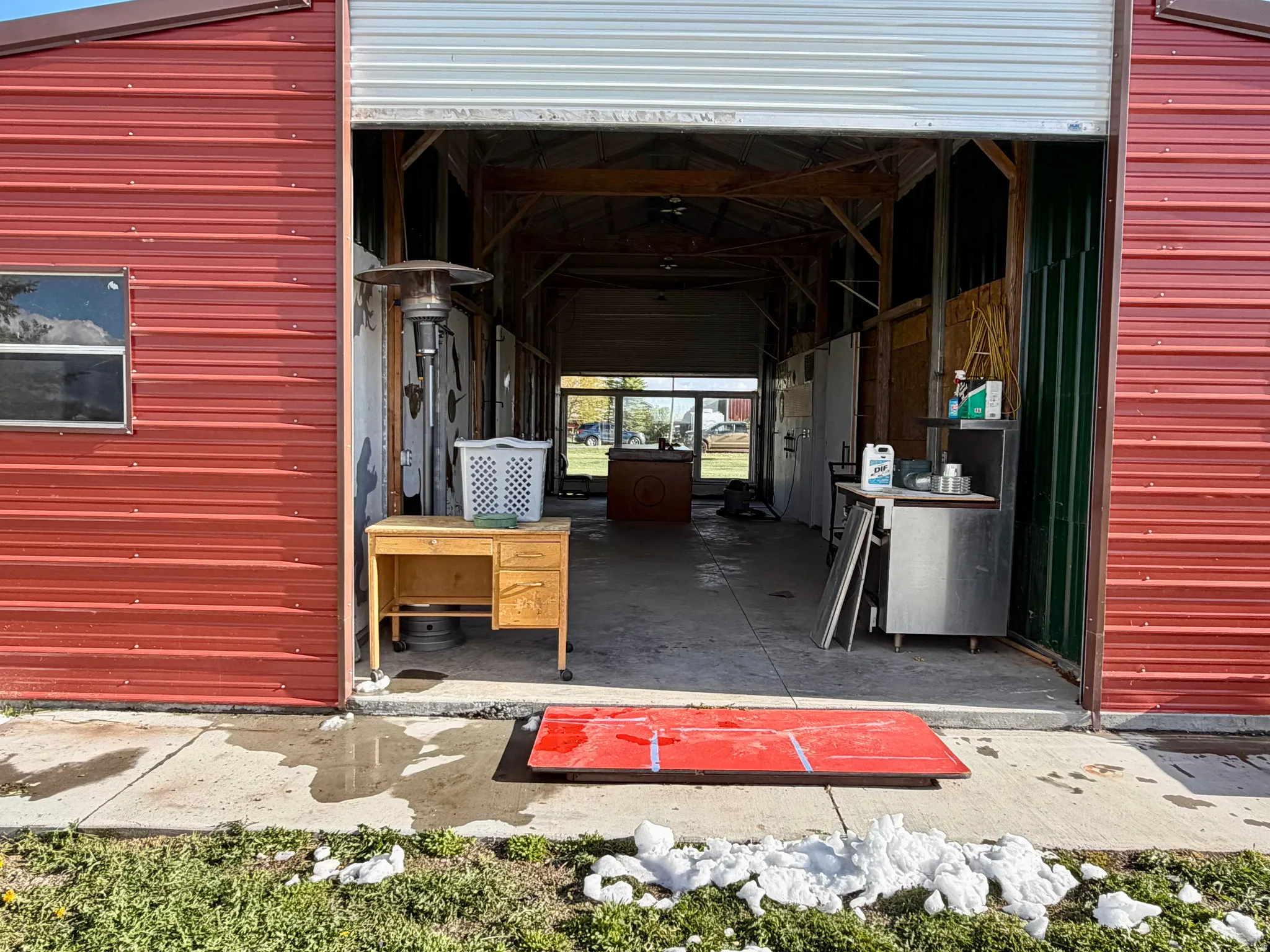 Red corrugated metal exterior featuring a roll-up garage door entrance