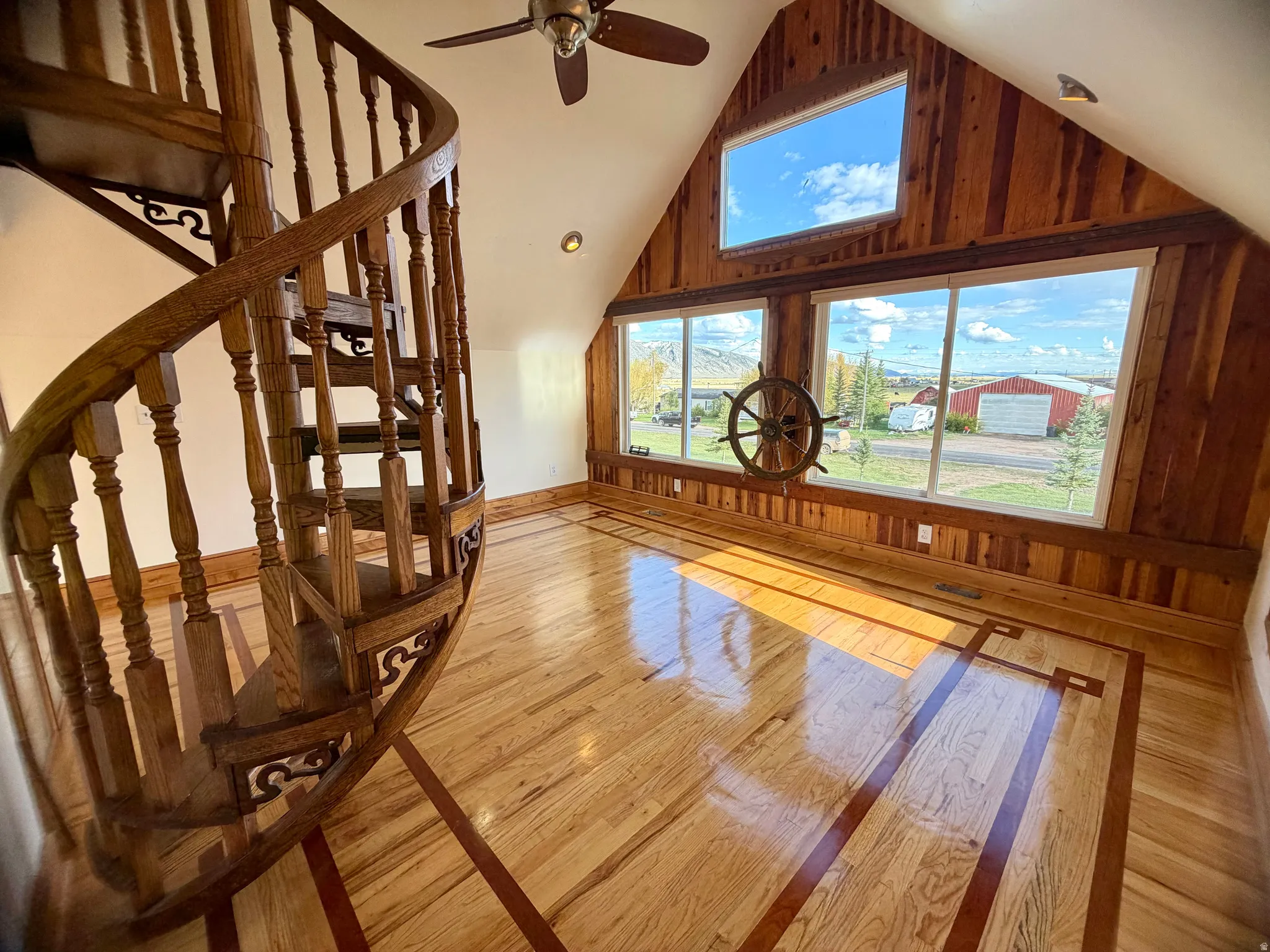 Hardwood flooring with inlaid accents and a spiraling wooden staircase