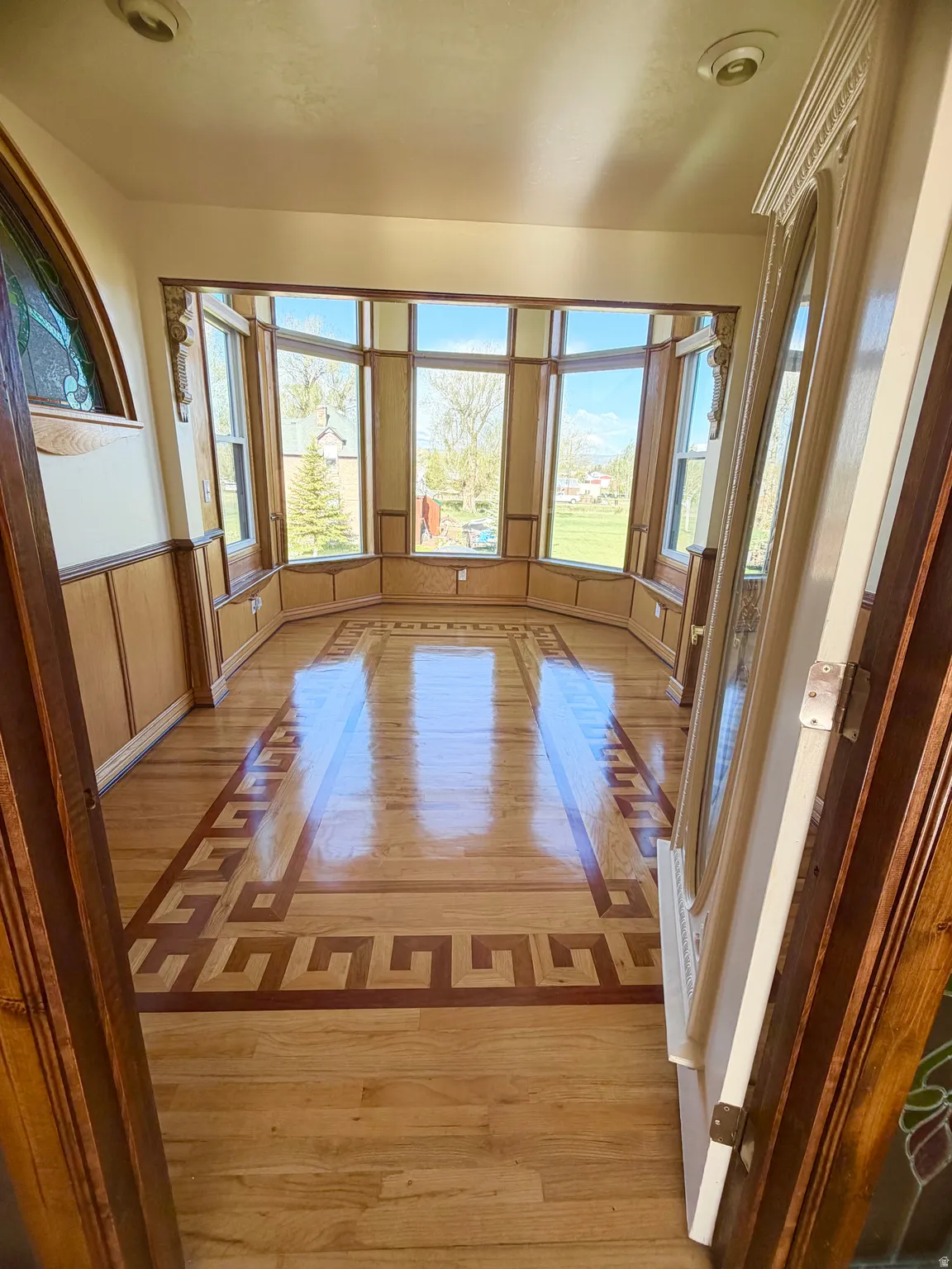 Bay window featuring wood-finish flooring with an intricate inlay design
