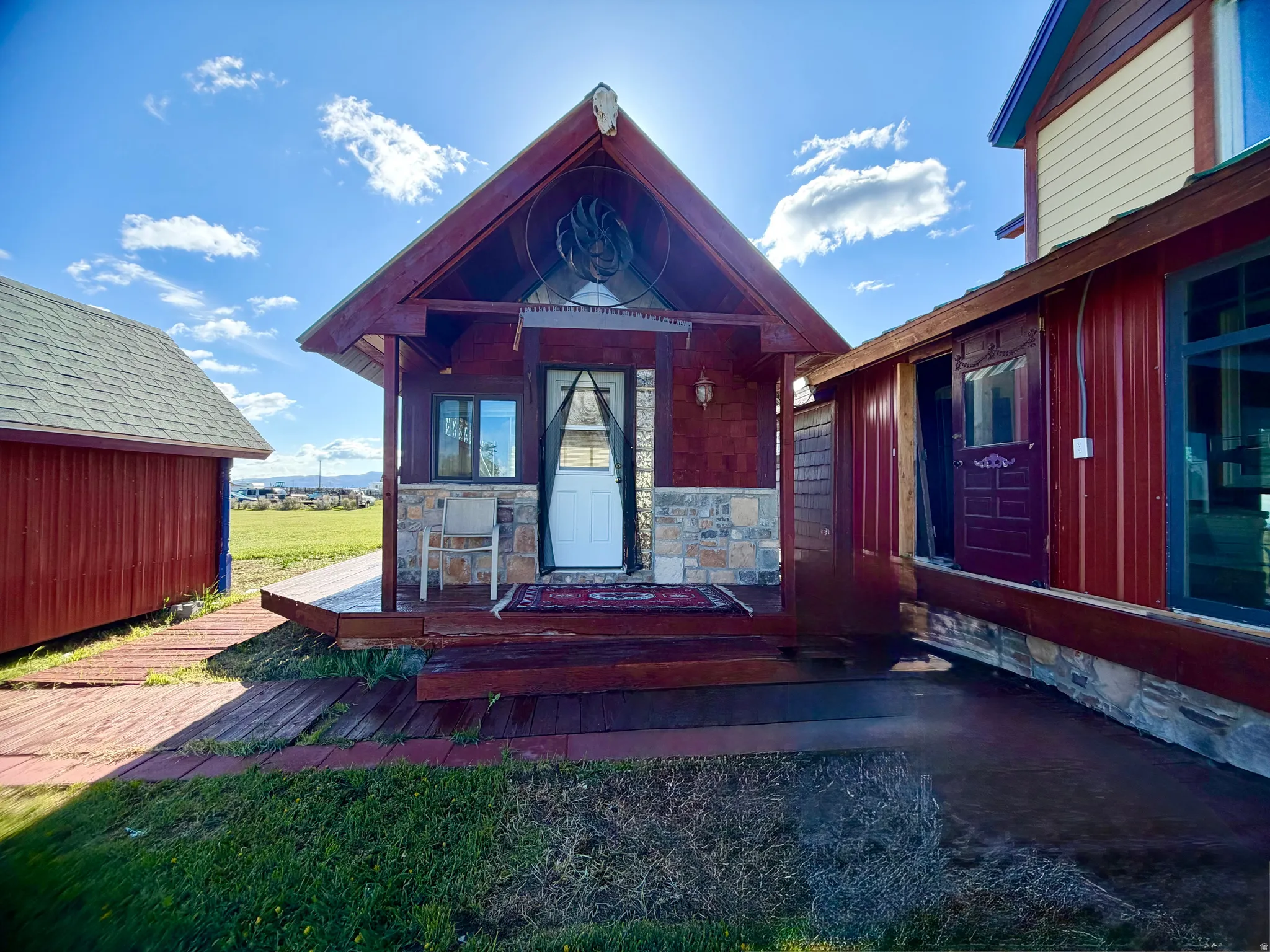 Rustic exterior featuring red wood siding and stone veneer accents