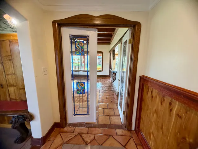 Entryway featuring terracotta tile flooring with decorative accents