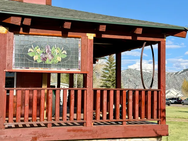 Covered front porch with wood railings and structural posts