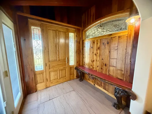 Double wooden entry door with decorative glass sidelights