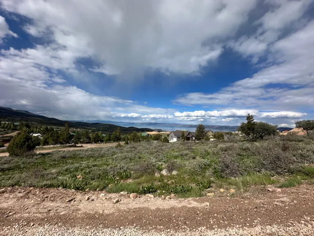 Expansive natural landscape featuring rolling terrain and distant water