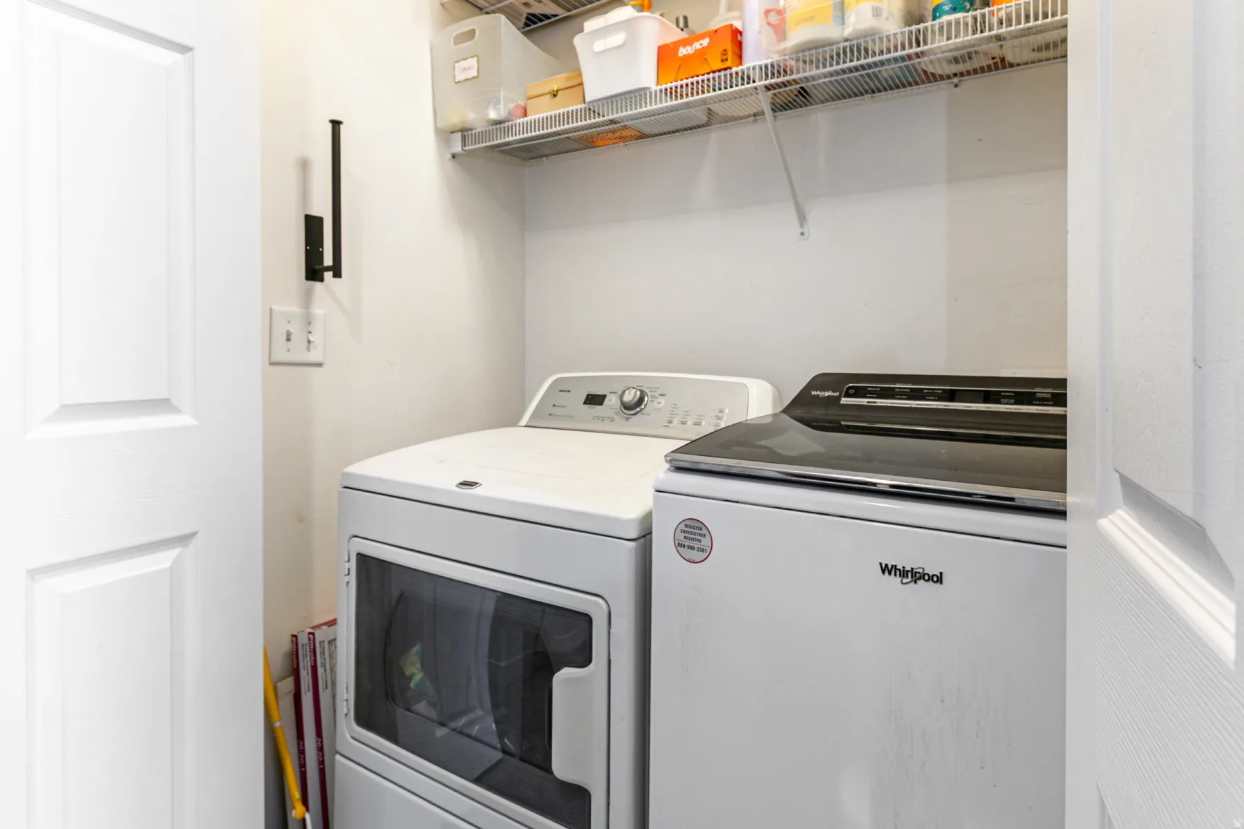Dedicated laundry area featuring a white dryer with a glass window and a white top-load washing machine