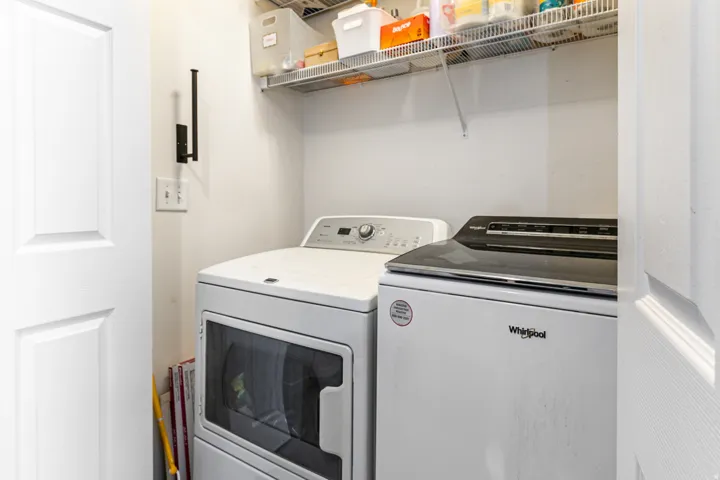 Dedicated laundry area featuring a white dryer with a glass window and a white top-load washing machine