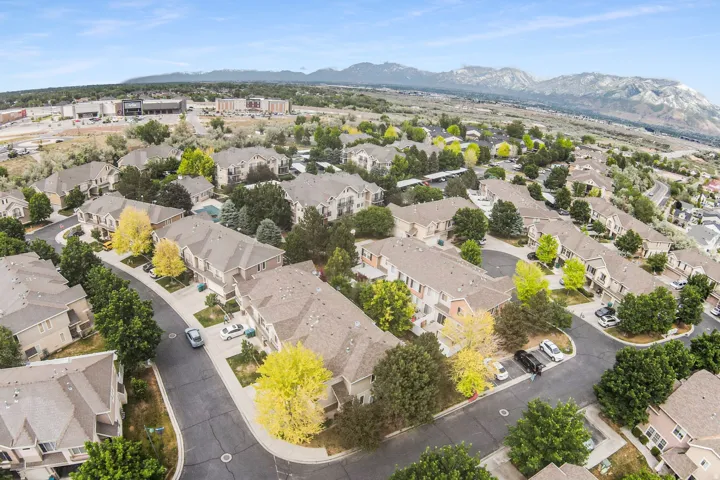 Aerial view of a residential community featuring multiple multi-story townhouse-style properties with pitched roofs and varied exterior finishes