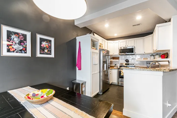 Modern kitchen featuring white cabinetry, stainless steel appliances, and a subway tile backsplash