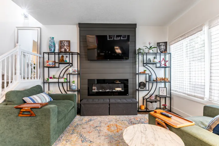 Living area featuring a shiplap accent wall with an inset electric fireplace and integrated media space
