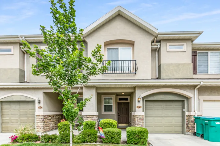 Stucco exterior featuring an arched entryway and stone accents