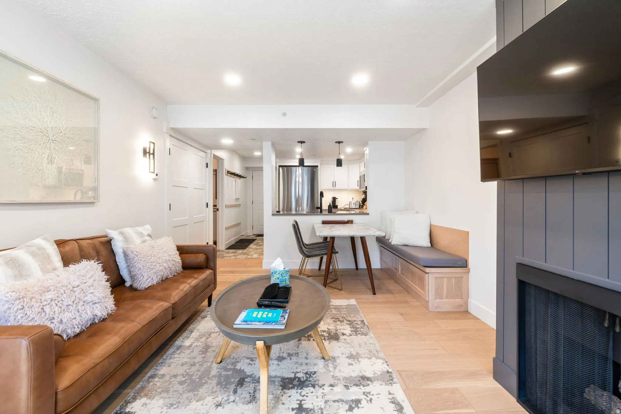Open-concept living space with light wood-finish flooring