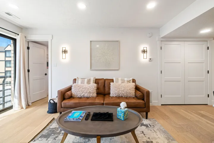 Bright living space featuring light wood-finish flooring and recessed ceiling lighting