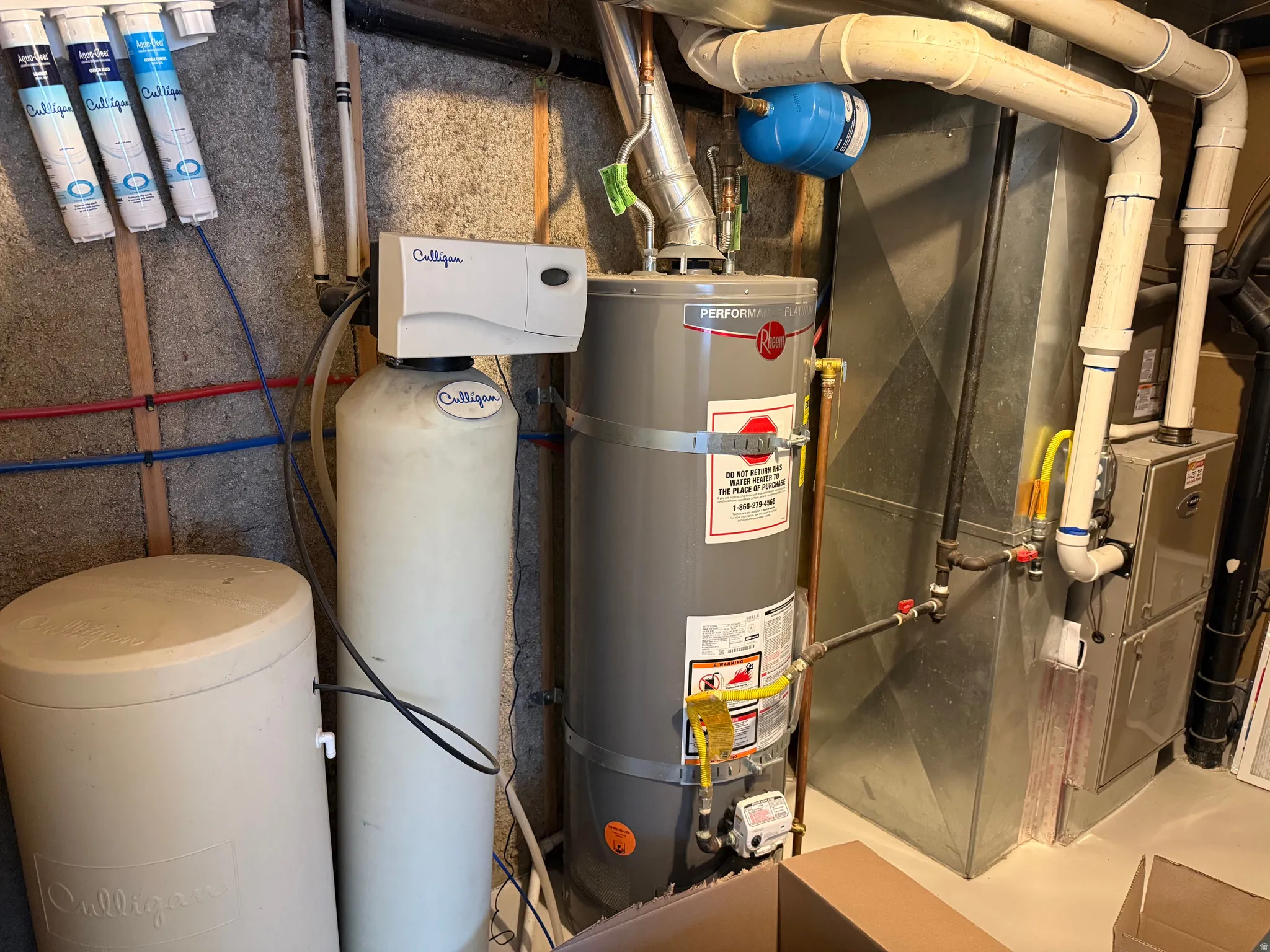 Mechanical room featuring a water heater, furnace, water softener system, and whole-house water filtration