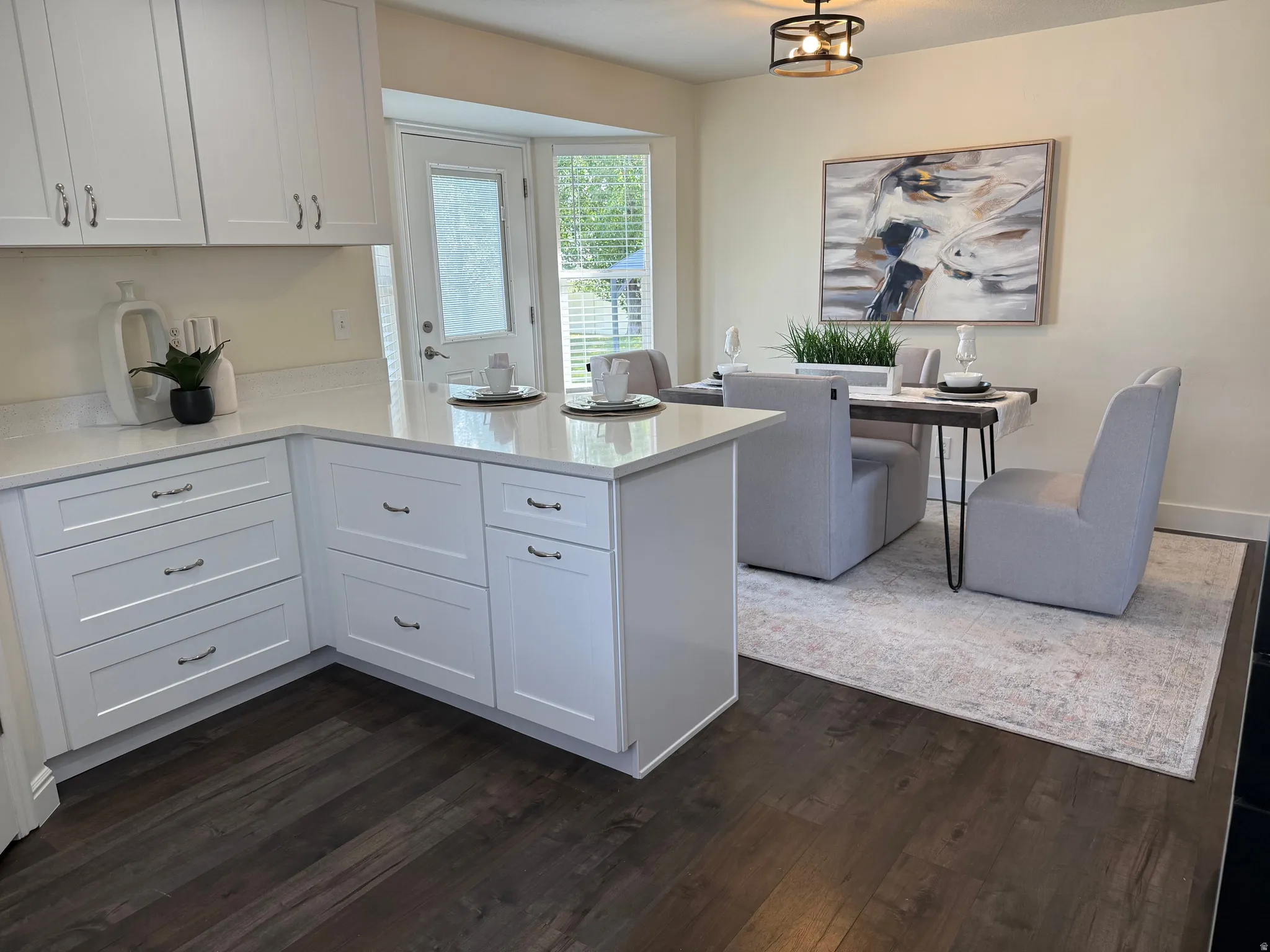 Kitchen with white shaker-style cabinetry, light-toned countertops, and wood-finish flooring