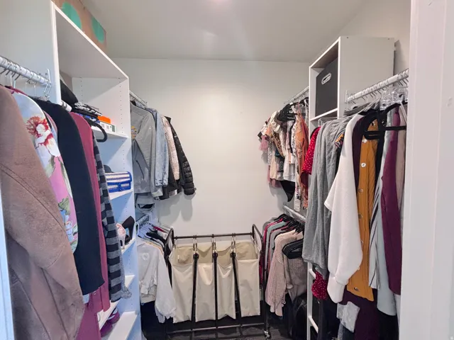 Walk-in closet featuring extensive built-in shelving, multiple hanging rods, and recessed lighting