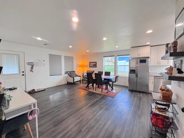 Open-concept living area featuring wood-finish flooring, recessed lighting, and multiple windows