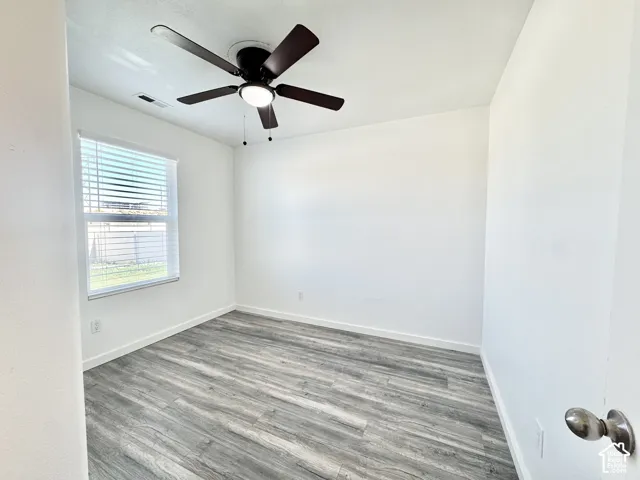 Recessed lighting, wood-finish flooring, ceiling fan with integrated lighting, and window with horizontal blinds