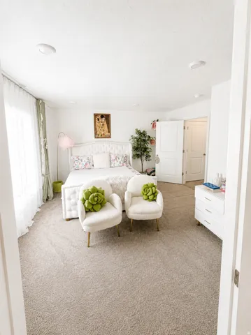 Carpeted bedroom featuring recessed lighting, a window with sheer and solid drapes, and a white paneled door