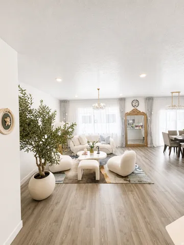 Open-concept living space with wood-finish flooring, recessed lighting, and multiple large windows