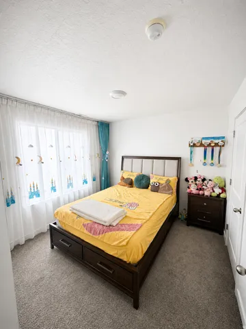 Bedroom featuring neutral-toned carpeting and white walls