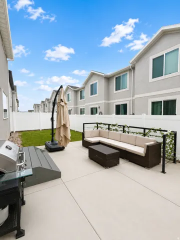 Expansive concrete patio with a modern black railing featuring decorative vines