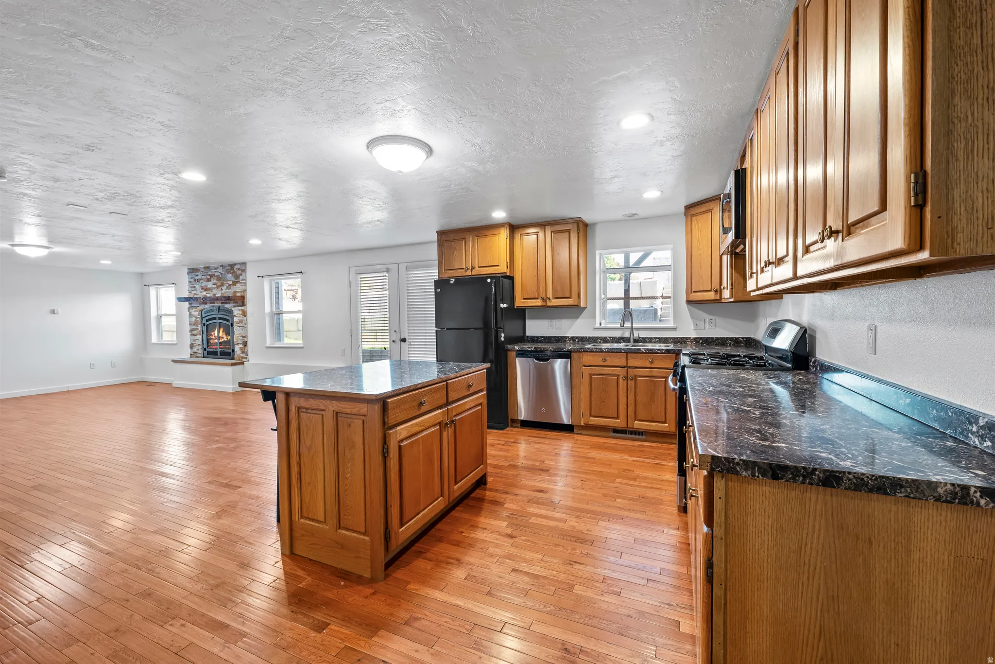 Kitchen featuring wood cabinetry, dark-toned countertops, and stainless-steel appliances