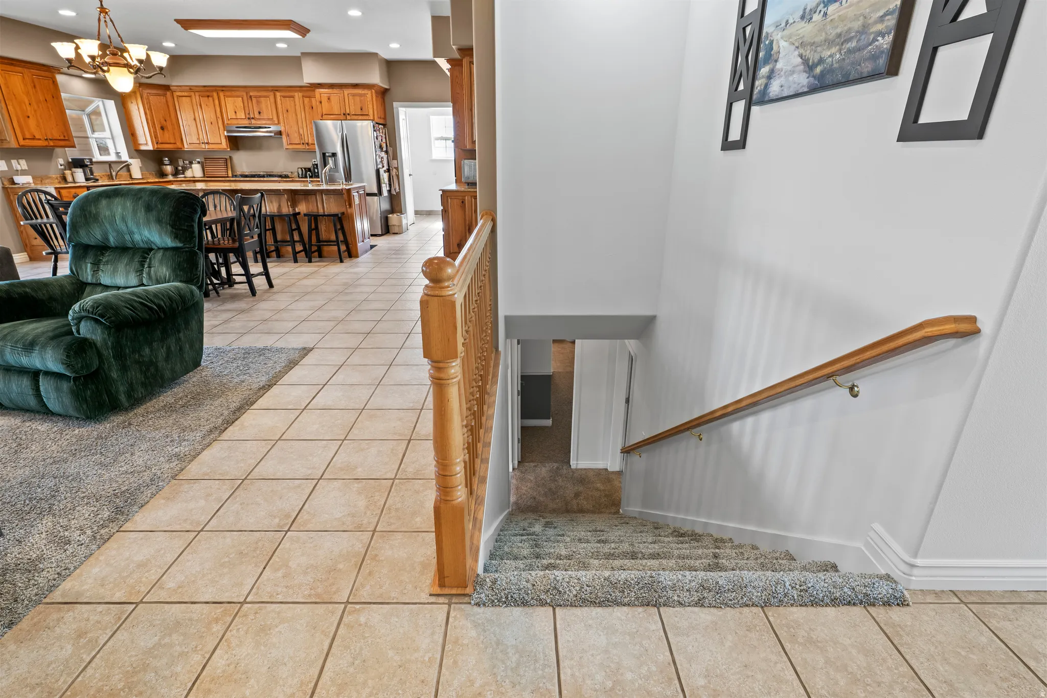 Carpeted staircase with a wood-finish handrail descending from the main level