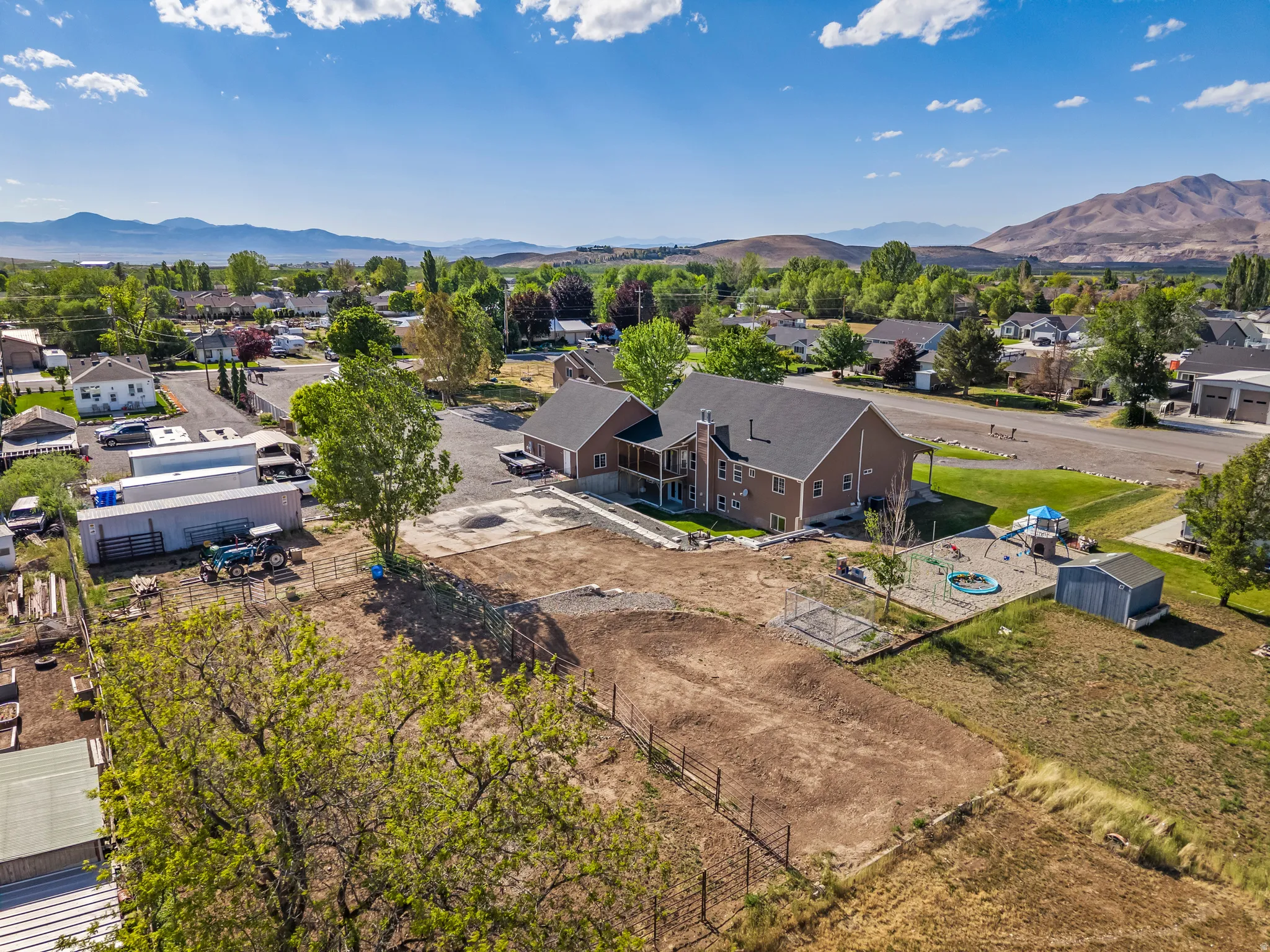 Expansive property featuring a multi-story residence with a covered porch and an elevated patio