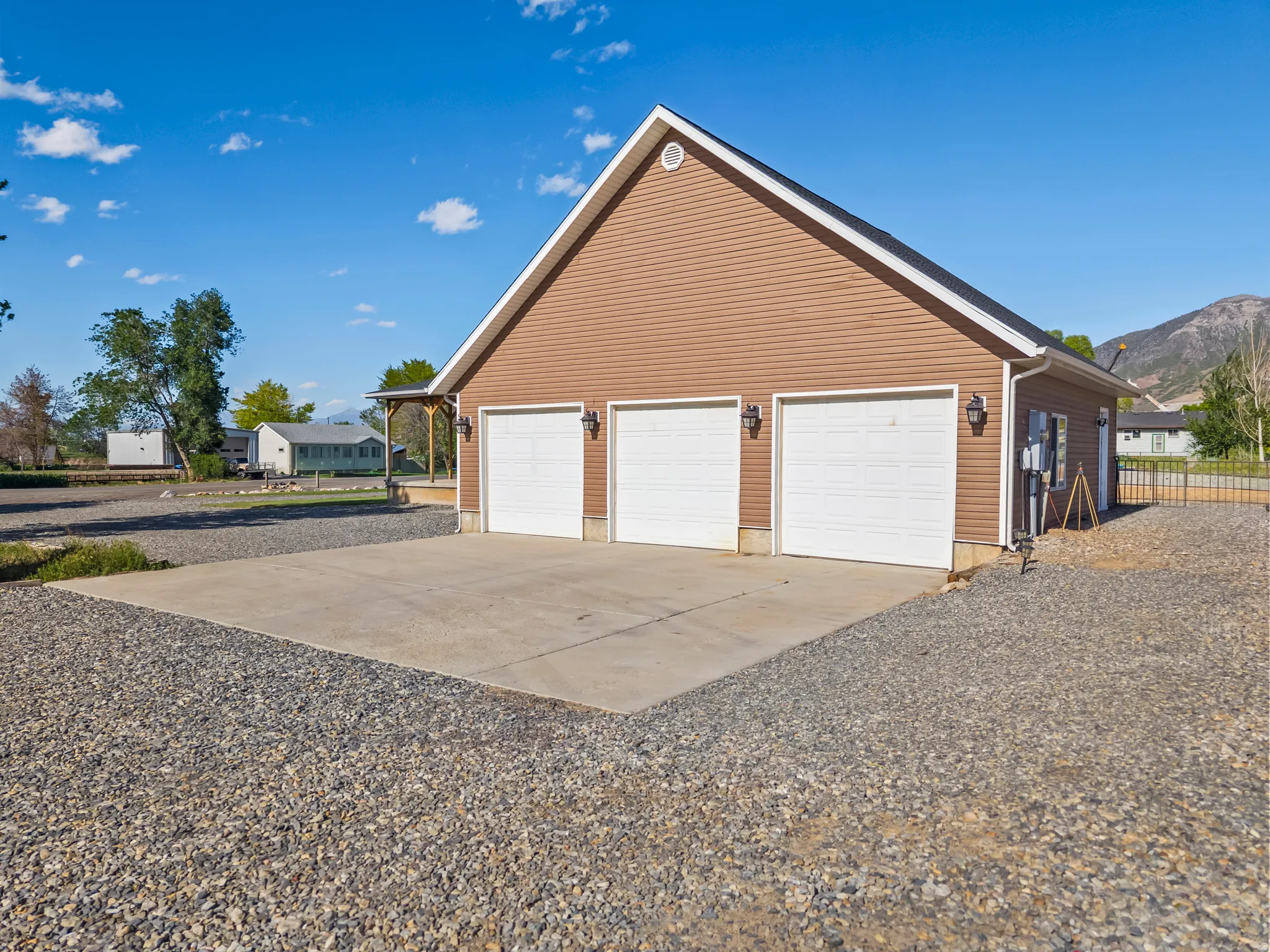 Detached three-car garage with brown siding and white garage doors