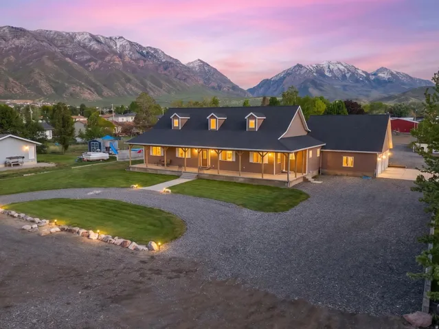 Mountain backdrop featuring a single-story home with a covered front porch, dormer windows, and attached garage