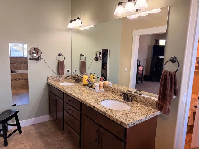 Master bathroom with double vanity with granite-style countertop and dual undermount sinks