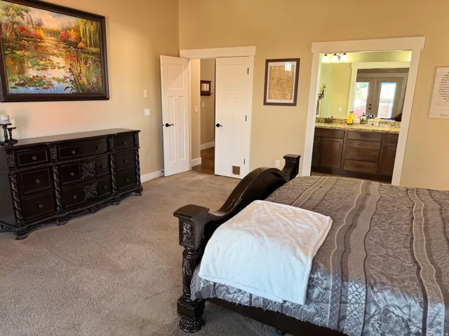 Carpeted master bedroom with neutral wall tones and white trim