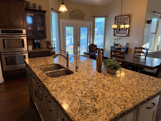 Spacious kitchen island with granite countertop and undermount stainless steel sink