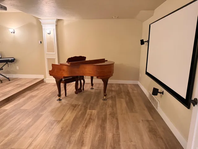 Theatre room- entertainment area featuring wood-finish flooring and an elevated platform