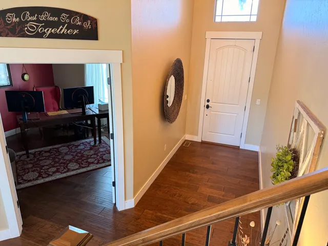 Entryway with wood-finish flooring, a paneled door, and transom window