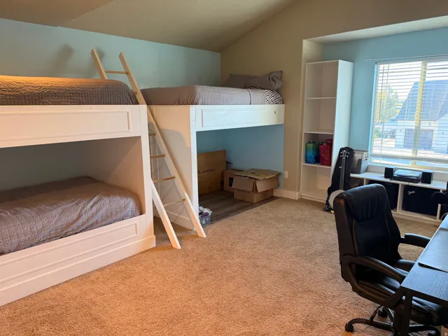 Room featuring built-in bunk beds with white frames and wooden ladders