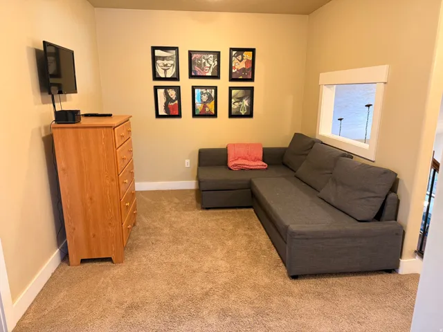 Carpeted loft area with interior space with neutral wall tones and white baseboards