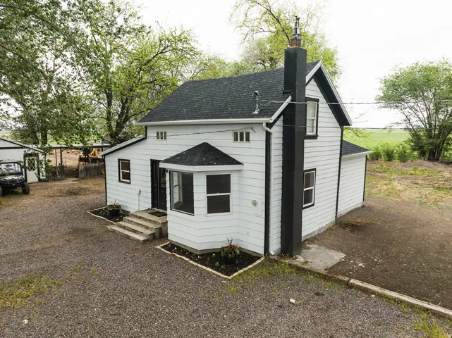 White-sided exterior with black trim and a prominent black chimney