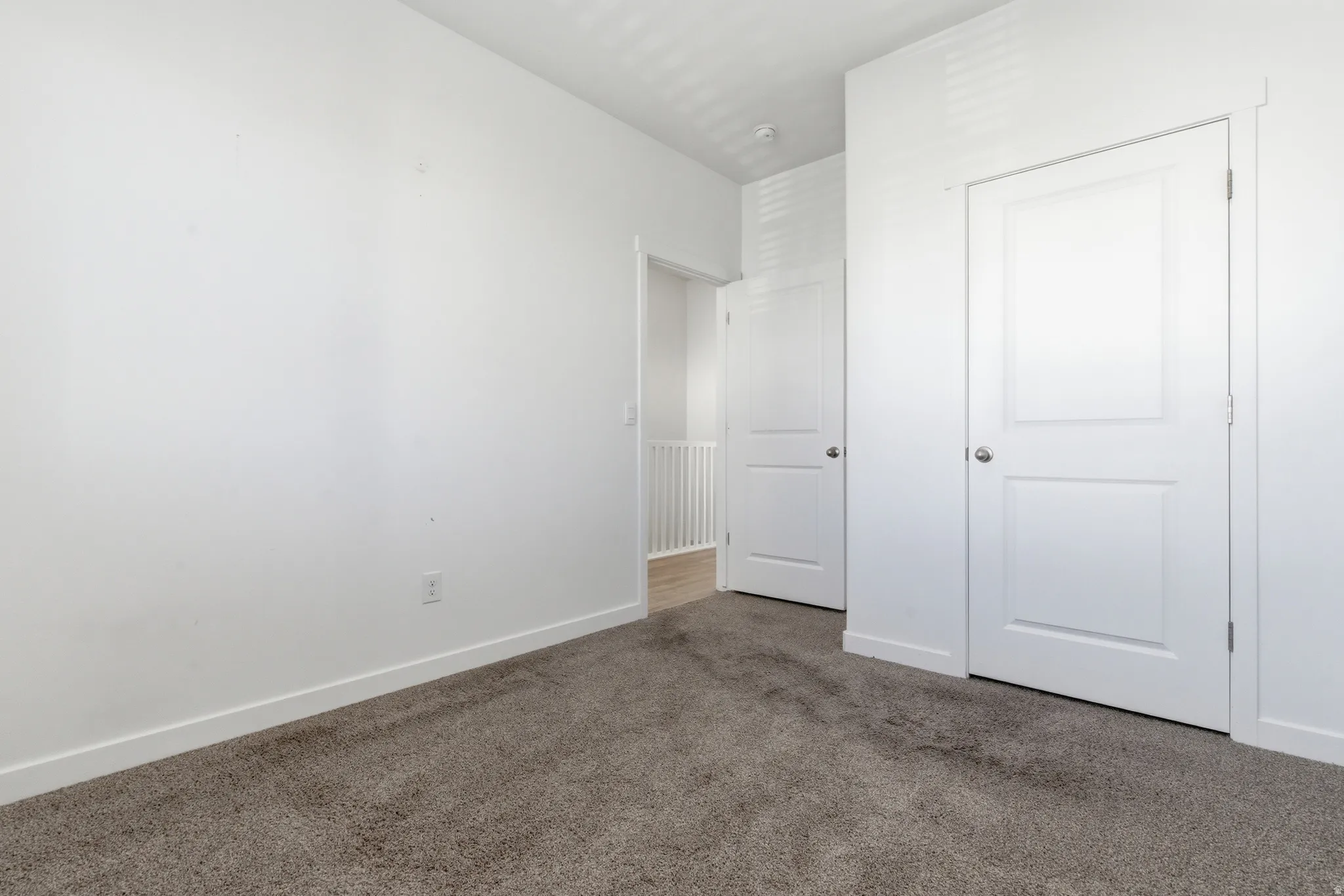 Neutral tone carpeting with white baseboards