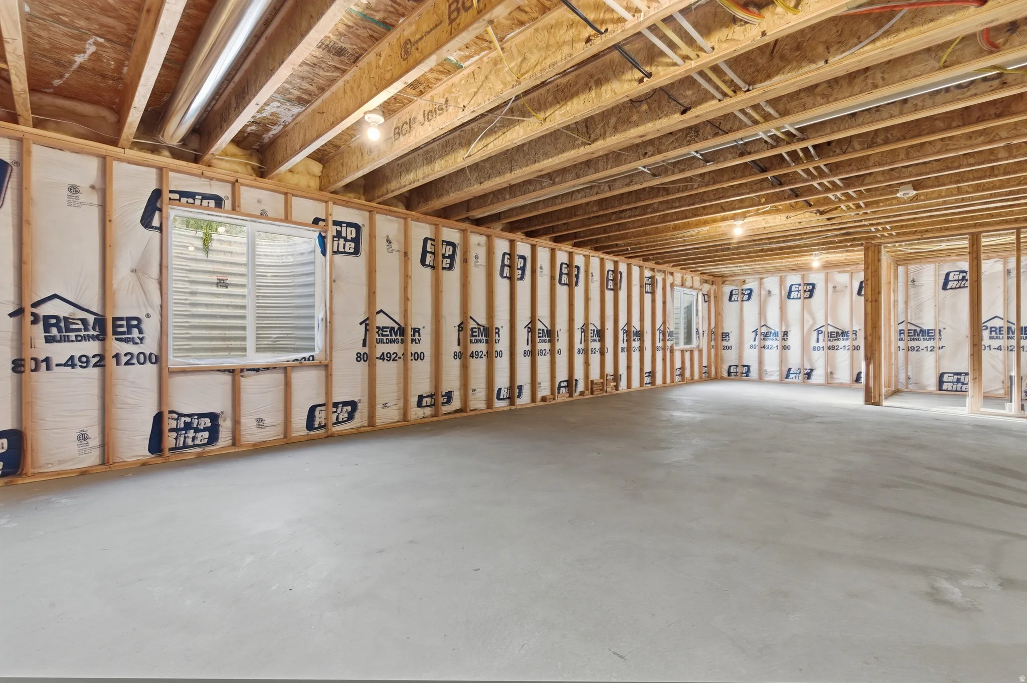 Expansive unfinished basement featuring a concrete floor, framed walls, and exposed ceiling joists